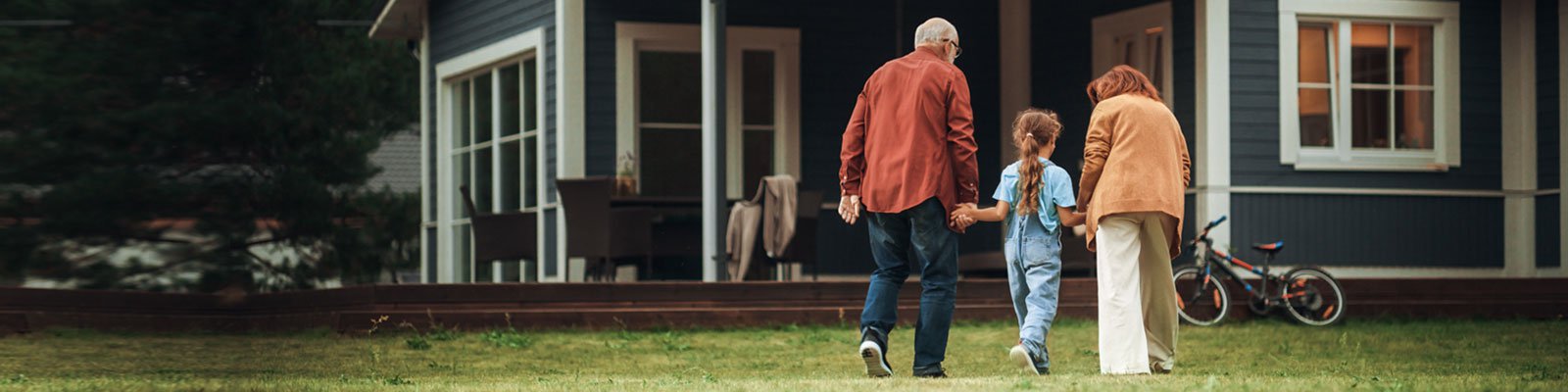 Grandparents walk with daughter toward blue house